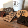 Wooden coasters with 'Hooray Ranch' branding on a wooden surface.
